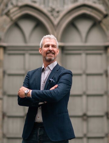 En mann står foran en kirkedør