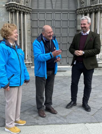 Et eldre par står utenfor Nidarosdomen og snakker med en mann i dress. Et eldre par står utenfor Nidarosdomen og snakker med en mann i dress.