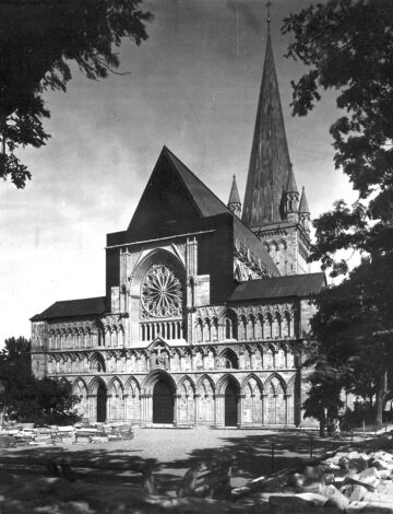 Et gammelt sort-hvitt foto viser en delvis gjenreist kirkevegg.