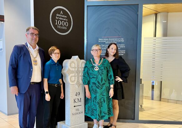 To ordførere og to damer står ved en milestein