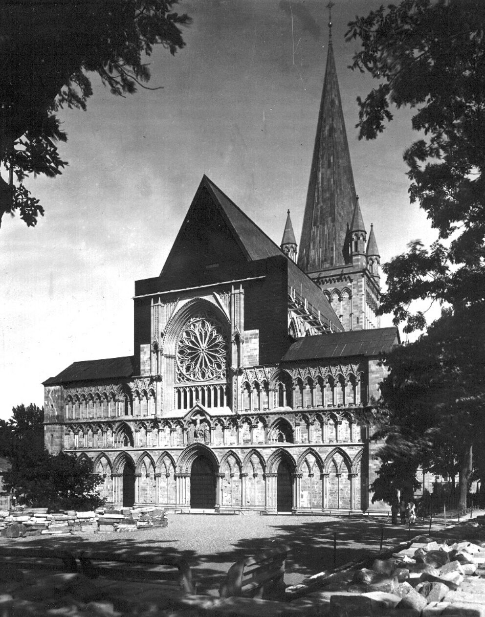 Et gammelt sort-hvitt foto viser en delvis gjenreist kirkevegg.