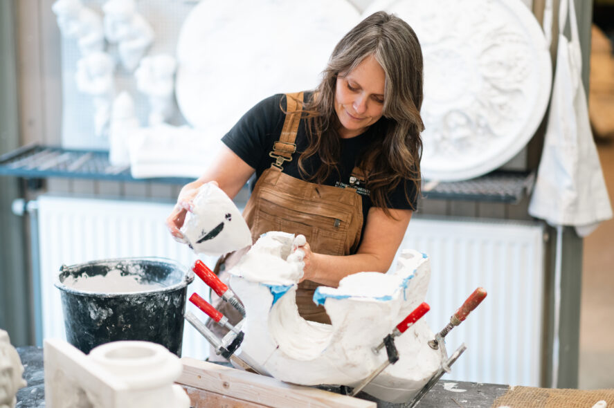 En gipsmaker støper et ornament i gips.